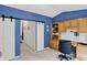 Blue home office boasts a sliding barn door for privacy, custom built in shelving, and a desk for work at 5011 Amber Creek Pl # 310, Indianapolis, IN 46237