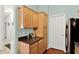Kitchen with wooden cabinetry, laminate countertops, and a view to the hallway at 5011 Amber Creek Pl # 310, Indianapolis, IN 46237