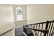 Carpeted stairwell with black metal railings, wood handrails, tall window, and chandelier at 5011 Amber Creek Pl # 310, Indianapolis, IN 46237