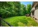 Well-maintained backyard featuring a wooden deck and chain link fence, surrounded by lush greenery at 5055 Turkey Track Rd, Martinsville, IN 46151