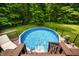 Backyard pool surrounded by lush greenery and a privacy fence, perfect for summer relaxation and fun at 5055 Turkey Track Rd, Martinsville, IN 46151