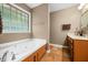 Bathroom featuring a soaking tub, tile floors, a window, and a sink with a vanity at 5055 Turkey Track Rd, Martinsville, IN 46151