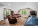 Living room featuring a leather couch and chair with wood floors, and large windows at 5055 Turkey Track Rd, Martinsville, IN 46151