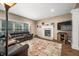 Cozy living room with a brick fireplace, plush seating, and a large window offering natural light at 5055 Turkey Track Rd, Martinsville, IN 46151