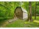 Backyard shed with a ramp nestled in the backyard woods at 5055 Turkey Track Rd, Martinsville, IN 46151