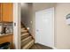 Carpeted staircase leading to upper level, adjacent to wood-paneled kitchen cabinets at 5055 Turkey Track Rd, Martinsville, IN 46151