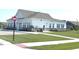 Community clubhouse with white siding, professional landscaping, and manicured lawn at 5103 Covington Ave, McCordsville, IN 46055