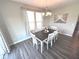 Bright dining room featuring a table and chairs set with gray wood flooring and a window with stylish curtains at 5103 Covington Ave, McCordsville, IN 46055