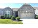 Charming gray brick home with a two-car garage, well-manicured lawn, and beautiful landscaping at 5103 Covington Ave, McCordsville, IN 46055
