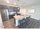 The open kitchen has stainless appliances, a large island with seating, and stylish dark cabinetry at 5103 Covington Ave, McCordsville, IN 46055