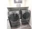 Laundry room featuring Whirlpool washer and dryer units, with overhead shelving for convenient storage at 5103 Covington Ave, McCordsville, IN 46055