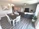 Open-concept living space with a dining area, modern lighting, and sightlines to the living room and kitchen at 5103 Covington Ave, McCordsville, IN 46055