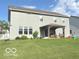 Rear exterior view of home featuring a large manicured yard and covered patio at 520 Ferndale Ln, Danville, IN 46122