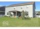 Rear exterior view of home with large manicured yard and covered patio at 520 Ferndale Ln, Danville, IN 46122