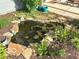 Backyard pond landscaped with a variety of plants and greenery at 520 Ferndale Ln, Danville, IN 46122