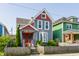 Charming two-story home featuring a colorful exterior, well-maintained lawn, and inviting front porch at 525 Orange St, Indianapolis, IN 46203