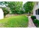 Lush backyard featuring green grass and a patio seating area, surrounded by trees and a fence at 535 Radburn Dr, Indianapolis, IN 46214