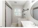Bright bathroom boasts a modern vanity, stylish fixtures, and a shower with a neutral-patterned shower curtain at 535 Radburn Dr, Indianapolis, IN 46214