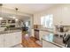 Bright kitchen featuring white cabinets, granite countertops, stainless steel appliances, and open access to the living room at 535 Radburn Dr, Indianapolis, IN 46214