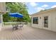 Open back deck area with table, chairs, and blue umbrella, perfect for entertaining outdoors at 59 Sycamore Dr, Carmel, IN 46033