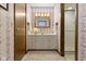 This bathroom features striped wallpaper, a white vanity, and a glass door shower at 59 Sycamore Dr, Carmel, IN 46033