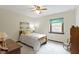This bedroom has a decorative ceiling fan and a window with views of the outdoors at 59 Sycamore Dr, Carmel, IN 46033
