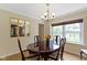 Bright dining room with hardwood floors, chandelier, large window, and gold-trimmed mirrors at 59 Sycamore Dr, Carmel, IN 46033