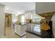 Bright kitchen featuring white cabinetry, black granite countertops, stainless steel appliances, and tile floors at 59 Sycamore Dr, Carmel, IN 46033