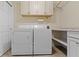 Functional laundry room with white cabinets, countertop, and side-by-side washer and dryer at 59 Sycamore Dr, Carmel, IN 46033