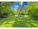 Expansive backyard with mature trees, a fire pit, and beautiful landscaping at 6125 N Olney St, Indianapolis, IN 46220