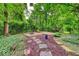 Wooded backyard space featuring a fire pit and patio area among lush trees at 6125 N Olney St, Indianapolis, IN 46220