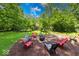 Picturesque backyard featuring fire pit area with seating surrounded by lush greenery at 6125 N Olney St, Indianapolis, IN 46220
