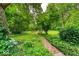 Lush backyard with brick path leading to landscaped area with chairs at 6125 N Olney St, Indianapolis, IN 46220