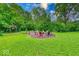 Sprawling backyard featuring a fire pit and lush landscaping with mature trees at 6125 N Olney St, Indianapolis, IN 46220