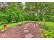 Lush backyard with a fire pit area, stone pathways, and a variety of plants at 6125 N Olney St, Indianapolis, IN 46220