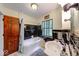 Bathroom with black tiled shower, traditional sink, shuttered window, and classic fixtures at 6125 N Olney St, Indianapolis, IN 46220