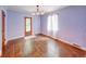 Bedroom with hardwood floors, light colored walls, decorative lighting, and a large window at 6125 N Olney St, Indianapolis, IN 46220