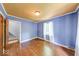 Bedroom with hardwood floors, two-tone walls, and a window with sheer curtains at 6125 N Olney St, Indianapolis, IN 46220
