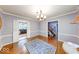 Dining room with hardwood floors, modern chandelier, white trim and a view of other rooms of the house through doorways at 6125 N Olney St, Indianapolis, IN 46220