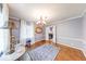 Dining room with hardwood floors, modern chandelier, and white trim with natural light coming in through large windows at 6125 N Olney St, Indianapolis, IN 46220