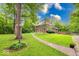 Charming brick home with manicured lawn, mature trees, and a inviting walkway to the front door and has exterior lighting at 6125 N Olney St, Indianapolis, IN 46220