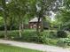 Exterior view of brick home with mature landscaping and wrought iron fence at 6125 N Olney St, Indianapolis, IN 46220