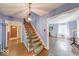 Foyer with hardwood floors, staircase, and chandelier with views to the entry door and the formal living room at 6125 N Olney St, Indianapolis, IN 46220