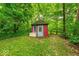Charming outbuilding with blue door and white bench surrounded by mature trees at 6125 N Olney St, Indianapolis, IN 46220