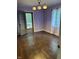 Room with hard wood floors featuring vintage light and a door leading outside at 6125 N Olney St, Indianapolis, IN 46220