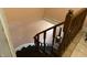 Winding staircase with dark treads and a wood handrail, offering a glimpse of lower level at 6125 N Olney St, Indianapolis, IN 46220