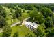 Aerial view of modern home next to golf course surrounded by mature trees and green landscape at 6164 Afton Crest, Indianapolis, IN 46220