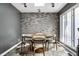 Modern dining room features a brick accent wall, large windows, travertine flooring and natural lighting at 6164 Afton Crest, Indianapolis, IN 46220