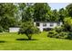An exterior view of a modern home with a white facade, black trim and verdant lawns and landscaping at 6164 Afton Crest, Indianapolis, IN 46220