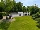 Modern home with a large yard, a sleek minimalist design, and a multi-car garage on a bright sunny day at 6164 Afton Crest, Indianapolis, IN 46220